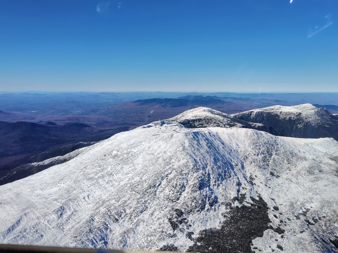 The snow-dusted Mount Washington summit seen from a glider